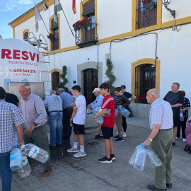 Vecinos de El Viso se acuden al camión cisterna que visita el pueblo para conseguir agua potable.