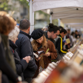 Varias personas miran libros en un puesto durante el día de Sant Jordi 2024, a 23 de abril de 2024, en Barcelona.