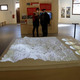 Dos visitants mirant el mapa de relleu dels Pirineus a la Verneda de Prats de Molló.