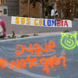 Una pancarta contra el presidente de Colombia, Iván Duque, durante su visita a España, en la plaza Arturo Barea de Lavapiés a 16 de septiembre de 2021, en Madrid