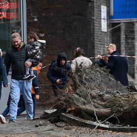 La gente pasa junto a un árbol caído derribado por fuertes vientos durante la tormenta Eunice en Londres, Gran Bretaña, el 18 de febrero de 2022.