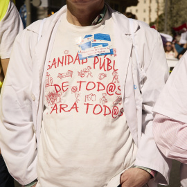 Varias personas, algunas con batas blancas, marchan en la manifestación convocada por entidades sociales, profesionales de la sanidad y organizaciones sindicales por la defensa del sistema sanitario público madrileño, a 26 de marzo de 2023, en Madrid (