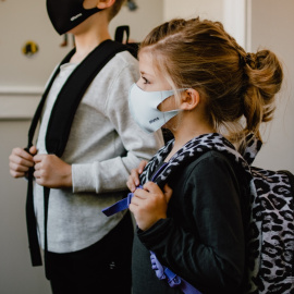 Dos niños en el colegio con mascarilla.