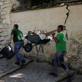 Un par de trabajadores cargan con una carretilla en una calle empinada de la localidad malagueña de Ronda. REUTERS/Jon Nazca