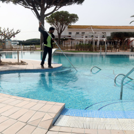 Un treballador netejant la piscina del càmping Les Medes de l'Estartit