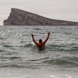 Un hombre se baña en la playa de Levante de Benidorm, en Alacant,  donde las temperaturas llegaron a superar los 25 grados a 18 de enero de 2024.