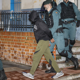 El presunto asesino de tres hermanos en Morata de Tajuña, Dilawar Hussein F.C., sale custodiado por guardias civiles tras el registro de su vivienda en Arganda del Rey.