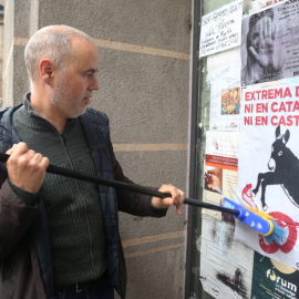 El cap de llista per Girona de Comuns Sumar, Eloi Badia, enganxa un cartell contra l'extrema dreta a Ripoll.