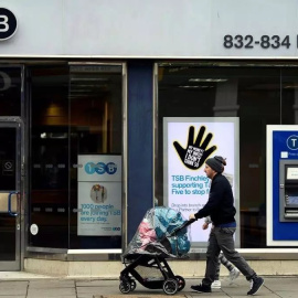 Una pareja camina junto a una sucursal del banco británico TSB en Londres, Reino Unido. EFE/Neil Hall