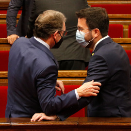 El conseller d'Economia i Hisenda, Jaume Giró, parla amb el president Aragonès al Parlament durant un ple .