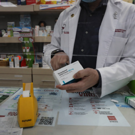 Un farmacéutico recorta el código de barras de una caja de Paracetamol en su farmacia, en Madrid a 20 de abril de 2020