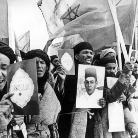 Voluntarios marroquíes participantes en la Marcha Verde con retratos del rey Hasan II, textos del Corán y banderas de Marruecos.