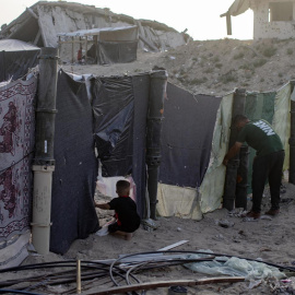 Un palestino desplazado y su hijo en el campamento de Khan Yunis.