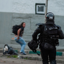 Un policía antidisturbios persigue a un manifestante durante una protesta contra el proyecto de ley de reforma fiscal propuesto por el gobierno de Colombia.