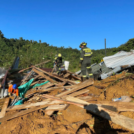 Varios rescatistas y policías trabajan en la recuperación de cuerpos tras el derrumbe en una carretera del departamento del Chocó, Colombia, a 13/1/2023