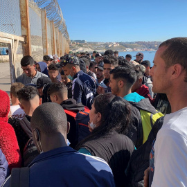 Un grupo de personas tratan de cruzar la valla fronteriza que separa Fnideq (Castillejos, Marruecos) y Ceuta este miércoles 19 de mayo de 2021.