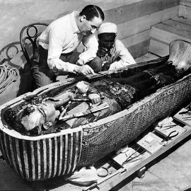 El arqueólogo británico Howard Carter examina el tercer ataúd de Tutankamón, el de oro macizo.