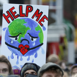 Una pancarta de la Tierra pidiendo ayuda en una manifestación contra la crisis climática en la semana de la Cumbre del Clima de Glasgow (COP26).