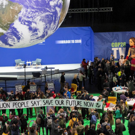 Un grupo de personas realiza una protesta en la COP26 con una pancarta que reza: "1,8 millones de personas dicen: salvad nuestro futuro ahora".