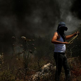 Un manifestante lanza piedras con su honda a miembros de las tropas israelíes después de una protesta contra unos asentamientos israelíes, este viernes en Nablus, Palestina.