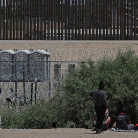 Policías de la Guardia Nacional de Texas dialogan por medio de altavoces con migrantes, en el muro que divide a México con Estados Unidos.