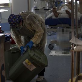 Una trabajadora de la limpieza limpia una papelera durante durante la segunda ola de coronavirus en el Hospital Universitario Ramón y Cajal, en Madrid (España).