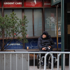 Un hombre en silla de ruedas espera a las puertas de un centro sanitario en Manhattan (Nueva York) este 8 de febrero de 2024.