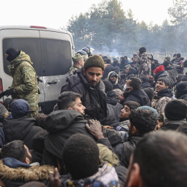 Refugiados y migrantes se agolpan para recibir ayuda humanitaria distribuída por soldados bielorrusos en un campo en la frontera con Polonia en la región de Grodno.