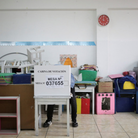 Un votante deposita su voto en una mesa de votación instalada en una escuela, en una segunda vuelta de las elecciones presidenciales entre la candidata de derecha Keiko Fujimori y el socialista Pedro Castillo.