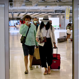 Varios turistas tras aterrizar en la terminal 4 del aeropuerto Adolfo Suárez Madrid Barajas