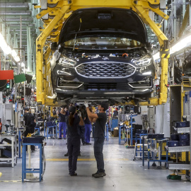 Dos trabajadores con un vehículo de la fábrica de Ford en Almussafes, a 24 de octubre de 2022.