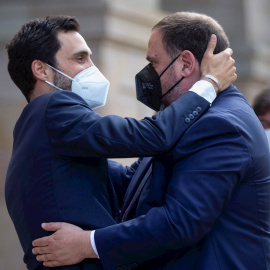 21/05/2021.- El presidente de ERC, Oriol Junqueras (d) - con un permiso penitenciario- saluda al expresident del Parlament, Roger Torrent (i) antes del comienzo de la segunda jornada del debate de investidura celebrada en el Parlament este viernes. EFE/En