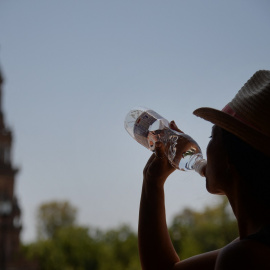 Una mujer bebe agua en Sevilla durante la ola de calor de junio de 2019.