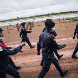 Agentes de la Policía congoleña desfilan en la pista del aeropuerto de Gbadolite, en el norte de la República Democrática del Congo, para la repatriación de refugiados centroafricanos a Bangui, el 15 de noviembre de 2021.