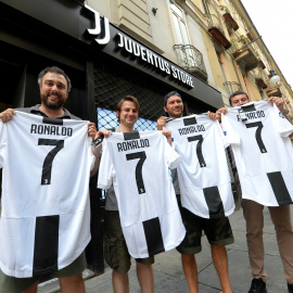 Varios hinchas de la Juventus posan con la camiseta del equipo con el nombre y el número de Ronaldo tras confirmarse su traspaso. /REUTERS