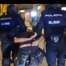 Momento en el que dos Mossos se llevan detenido al fotoperiodista Albert García.