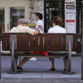 Una pareja de ancianos con mascarilla sentada en un banco, el 27 de julio de 2021, en Madrid, (España).