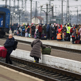 Refugiados ucranianos cruzan las vías del tren en la estación de Lviv.