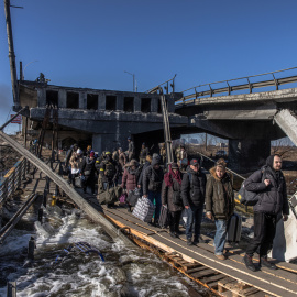 Ciudadanos de Irpin cruzan un puente destruido mientras huyen de la ciudad.