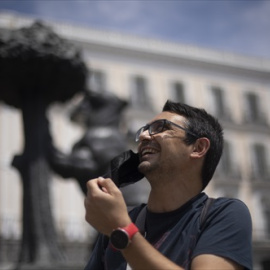 Un hombre se quita la mascarilla en la Puerta del Sol, a 18 de junio de 2021, en Madrid (España).