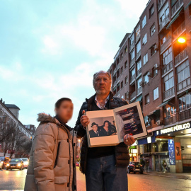 Adolfo Salazar y su hijo pequeño, José, sosteniendo una foto de sus difuntos padres.