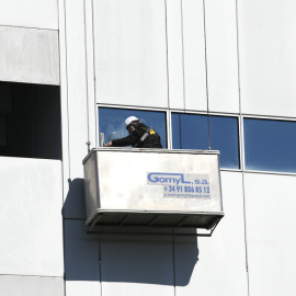 Un trabajador limpia los cristales de un edificio, en Madrid, a 21 de febrero de 2020.