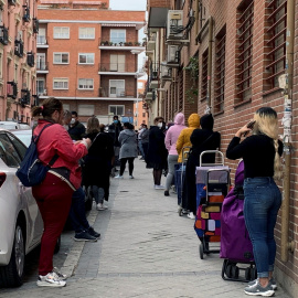 Fila de personas, en su mayoría mujeres, que esperan su turno para entrar en Cáritas, en Madrid. - EFE