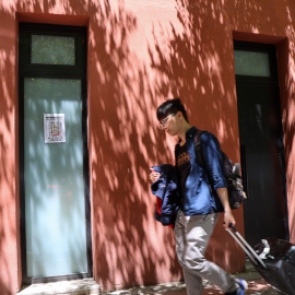 Fotografía de un turista frente a un local que se está reconvirtiendo en vivienda, en el madrileño barrio de Lavapiés, a 13 de junio de 2024.