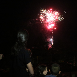 Pla obert d'un castell de focs vist des d'un terrat de l'Espluga de Francolí durant la revetlla de Sant Joan