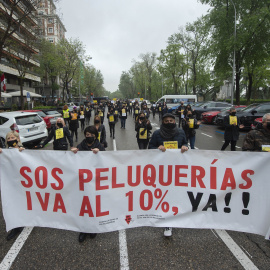 Un grupo de personas sostiene una pancarta donde se puede leer "SOS Peluquerías IVA al 10% ya!" en una concentración del sector de la imagen, a 26 de abril de 2021