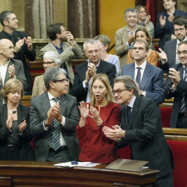 El presidente de la Generalitat en funciones, junto a miembros de su gobierno y diputados de Junts pel Si, aplaude tras aprobarse en el Parlament de Catalunya la resolución conjunta de Junts pel Sí y la CUP./ EFE