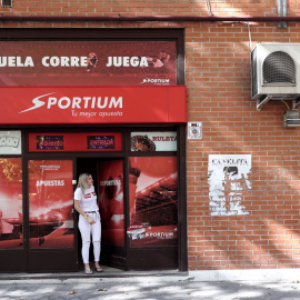 Local de apuestas de Sportium con una chica en la puerta de entrada. Arriba hay un cartel en el que se lee `Vuela, corre, juega´, en Madrid, a 3 de octubre de 2019.