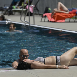 Imagen de archivo de una mujer tumbada en el bordillo de la piscina durante sus vacaciones. - EUROPA PRESS