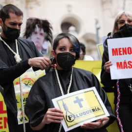 Un hombre rapa a una mujer durante una protesta de profesionales de peluquería y estética, frente al Senado, a 9 de diciembre de 2021, en Madrid.